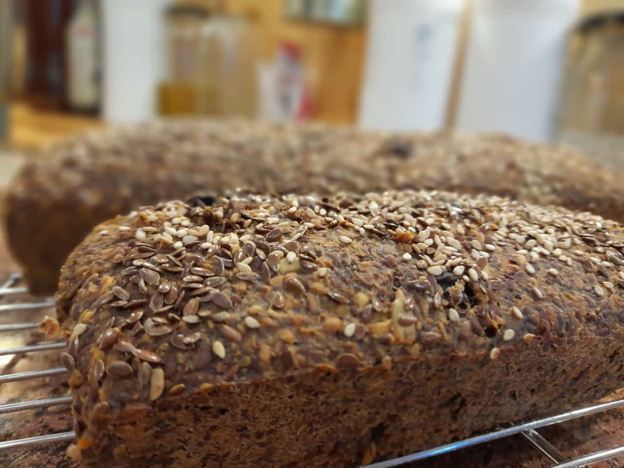 Ein frisch gebackenes veganes Brot mit Rosinen und Nüssen auf einem Kühlgitter. Ballaststoffreich und lange haltbar.